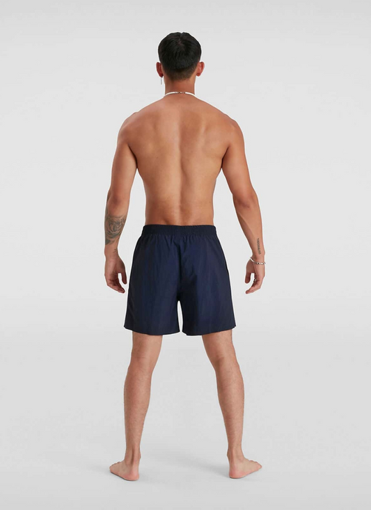 Man wearing navy swim shorts on a white background