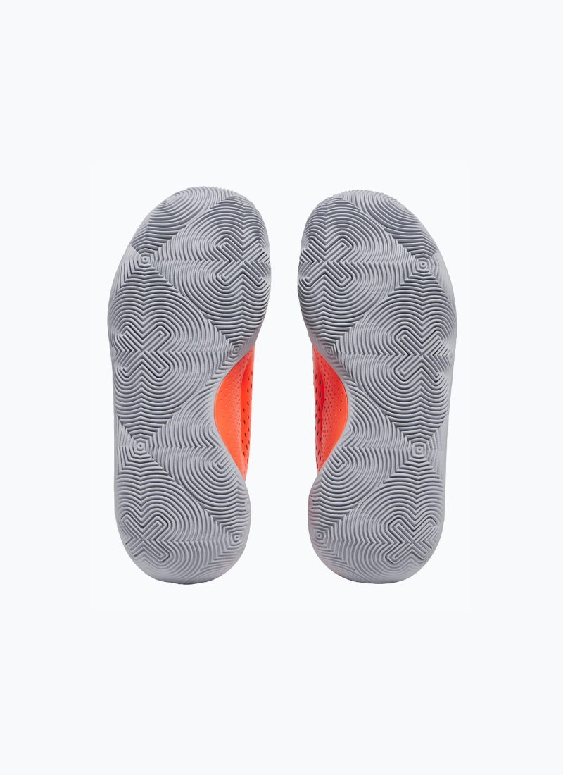Gray and orange sole of a pair of Black and orange Under Armour Under Armour GS Jet '23 Kids sneaker on a white background on a white background