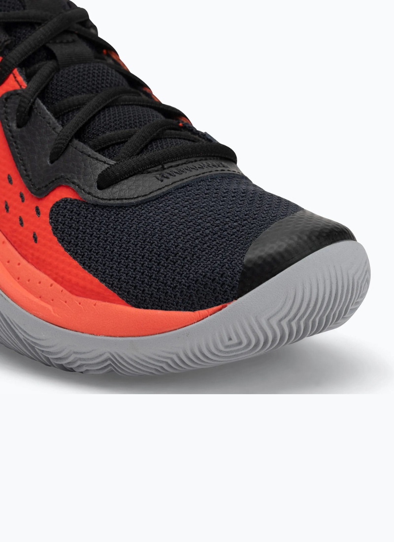 Close view of a pair of Black and orange Under Armour Under Armour GS Jet '23 Kids sneaker on a white background