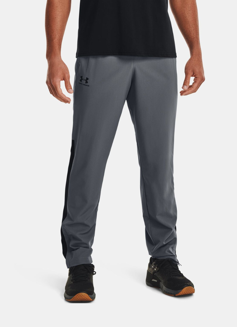 Person wearing gray Under Armour pants on a white background