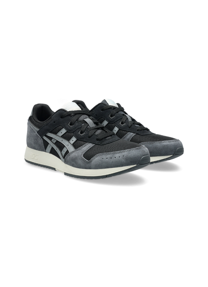 Front three-quarter view of a pair of Asics Lyte Classic Sneakers featuring dark grey suede mudguards, black mesh panels, grey side stripes, and off-white midsoles.