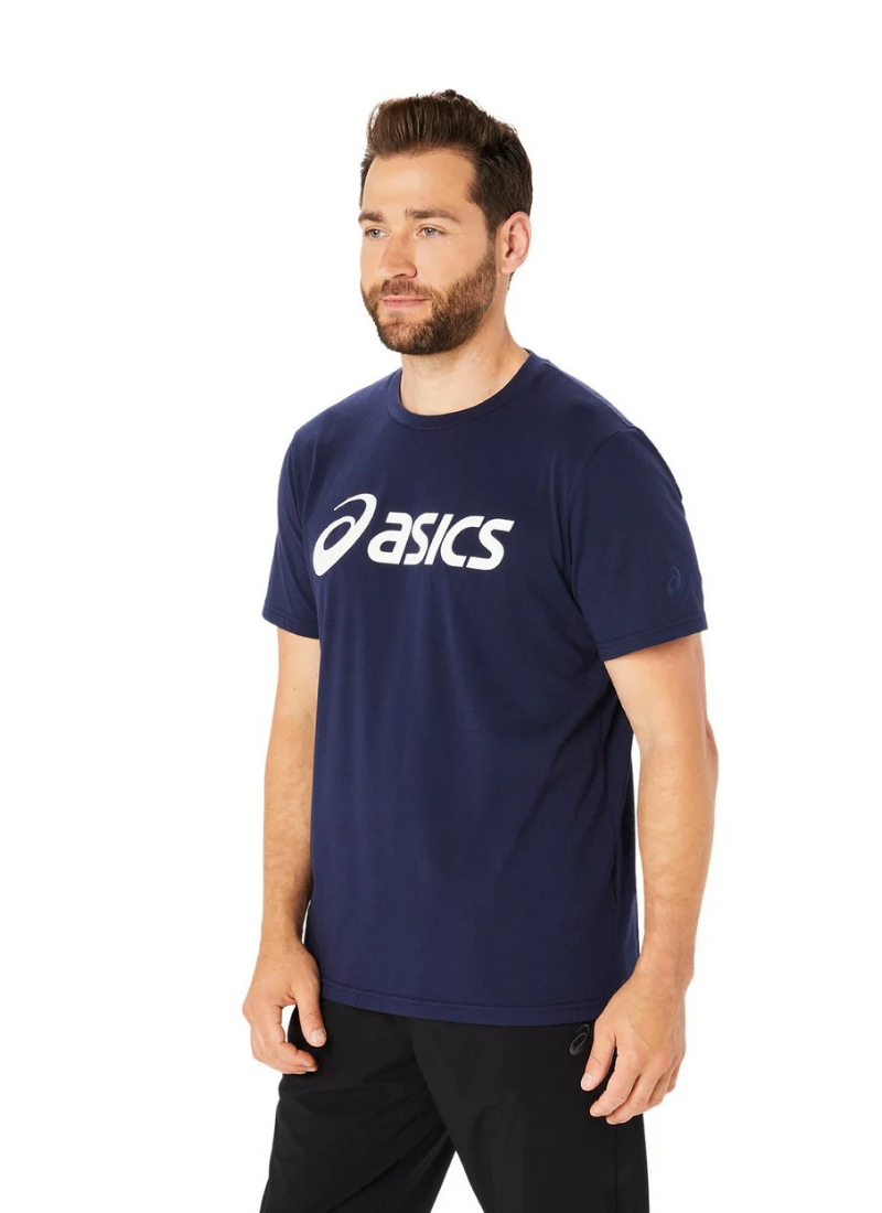 Man wearing a navy blue Asics t-shirt on a white background, angle view