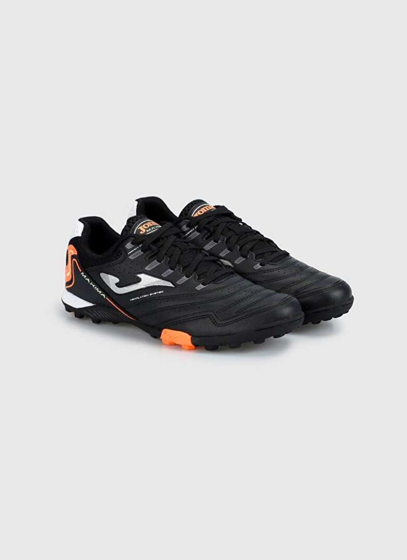 Front three-quarter view of a pair of black Joma Maxima 2301 turf football shoes with stitched leather forefoots, silver side logos, and bright orange outsole accents.
