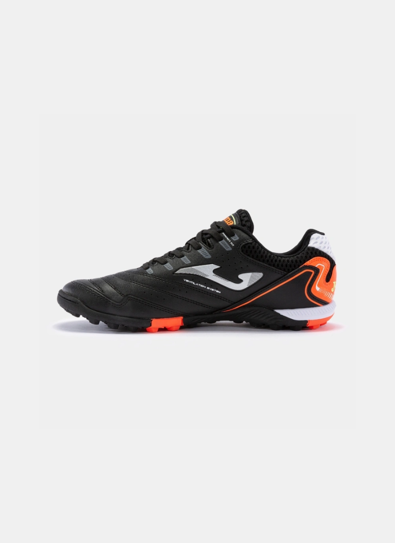 Lateral inner side profile view of the Joma Maxima 2301 turf shoe featuring a black upper, silver logo graphic, orange heel trim detailing, and low-profile turf studs.