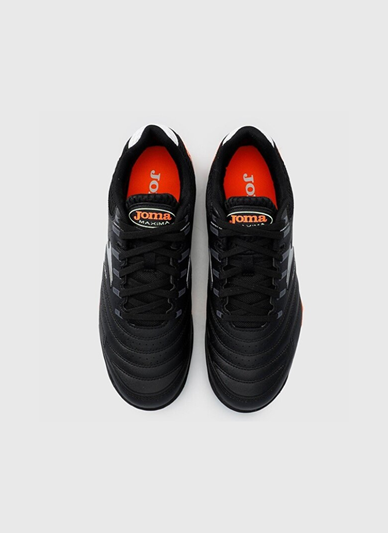 Overhead top-down view of the Joma Maxima 2301 turf shoes featuring black stitched uppers, black laces, orange insoles printed with "JOMA", and orange tongue tabs.