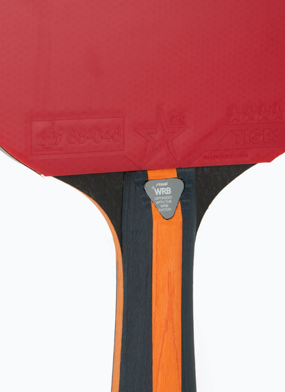 Close-up of STIGA Vision 4-Star table tennis racket showing WRB system badge, blade-to-handle junction, and ITTF rubber approval stamps on red rubber face