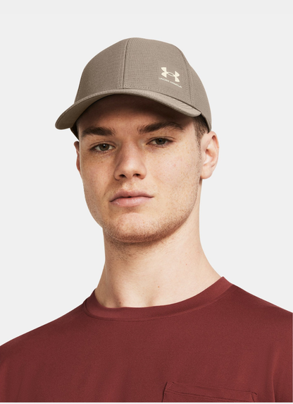Person wearing a Beige cap with Under Armour logo on a white background