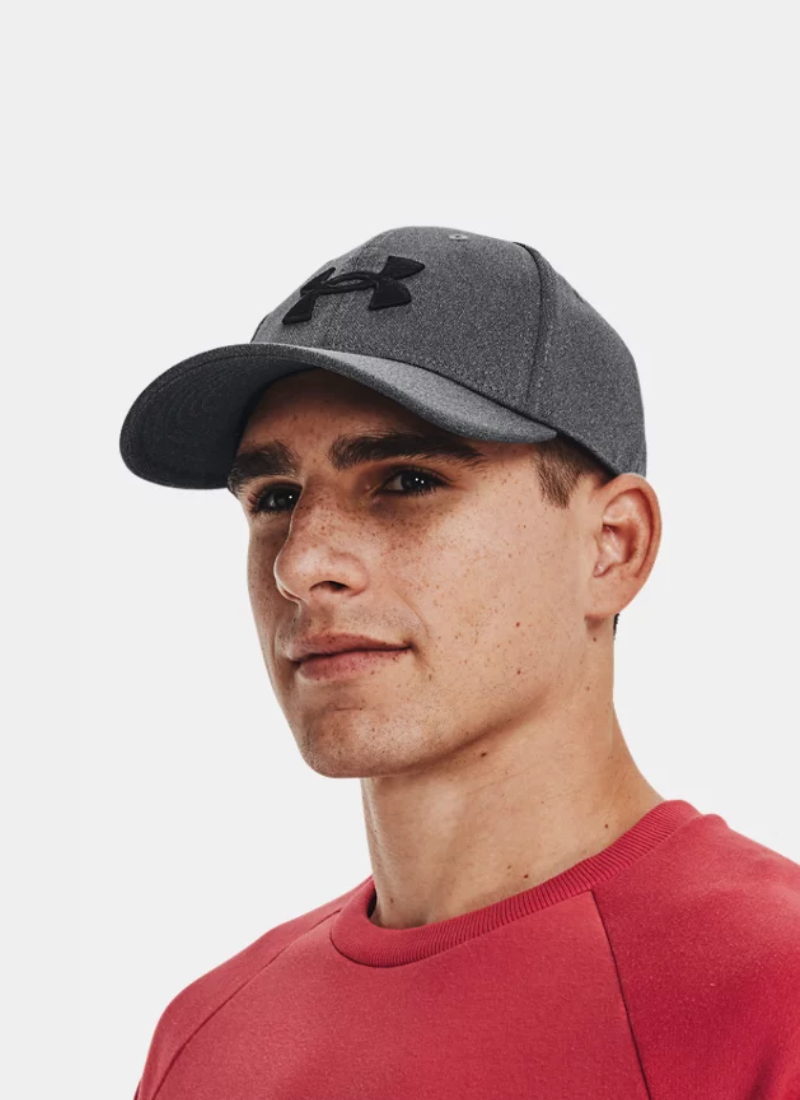 Person wearing a gray Under Armour cap on a white background