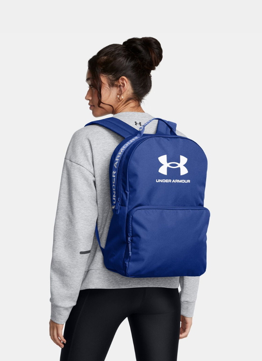Person wearing a blue Under Armour backpack on a white background