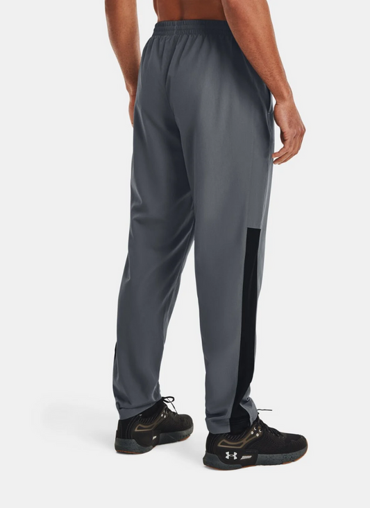 Back view of Person wearing gray athletic pants with a black stripe on a white background
