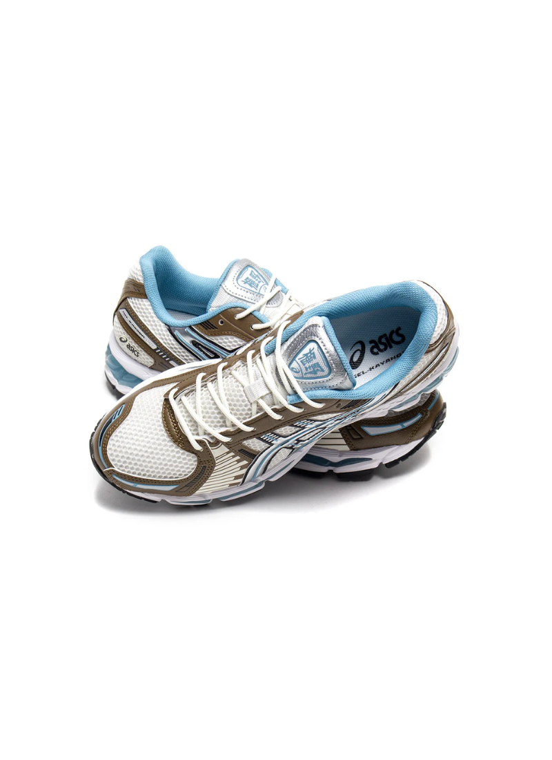 Pair of Asics Gel-Kayano 12.1 sneakers in Cream/Stillwater, crossed top-down view showing light blue lining and tongue branding.
