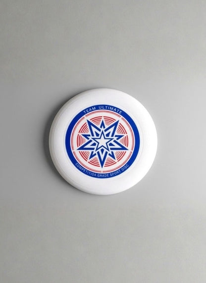 White flying disc with a blue and red star graphic and "Team Ultimate" print on a plain grey background